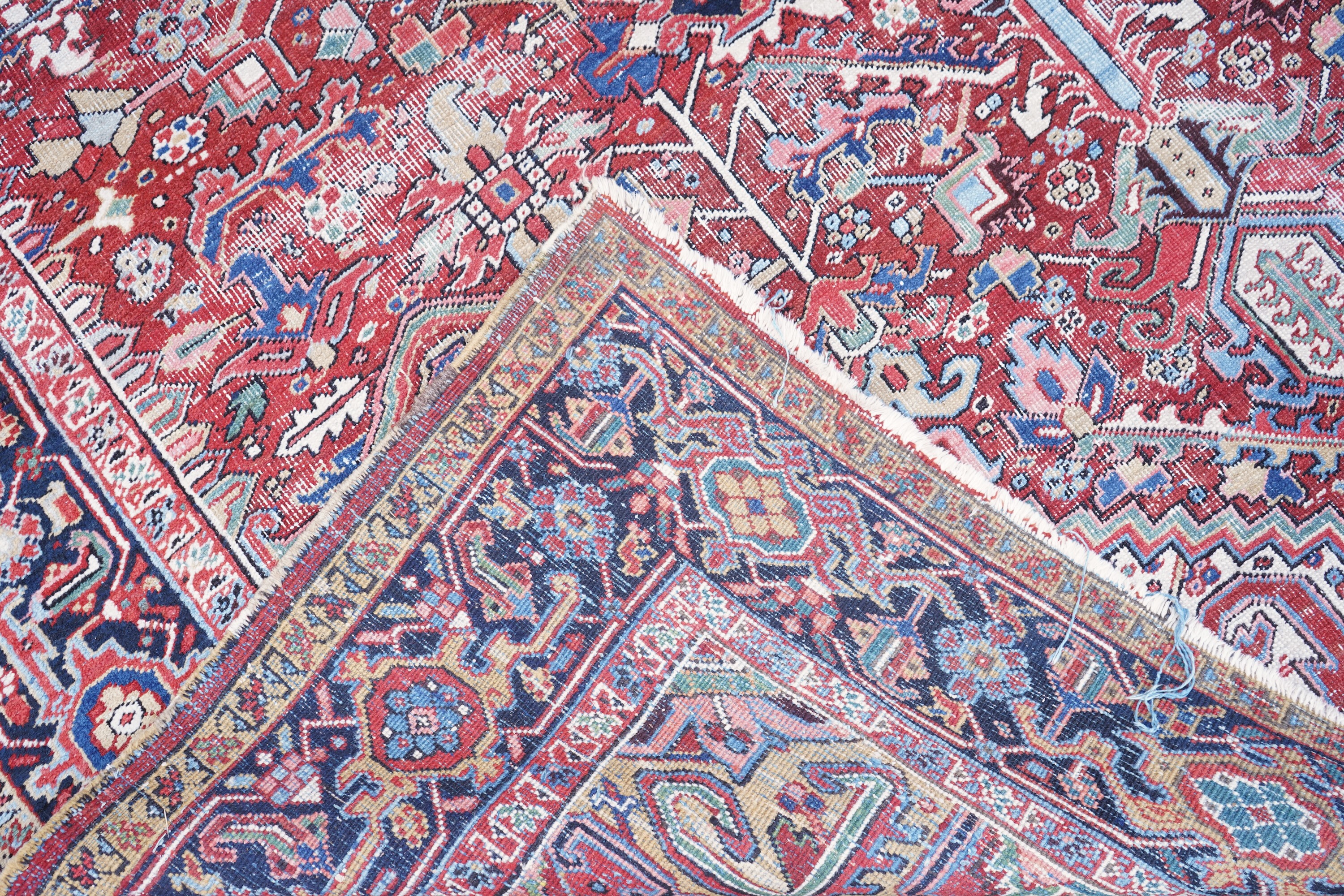 An antique Heriz brick red ground carpet with central